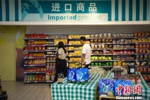 資料圖：民眾在超市進(jìn)口商品貨架前選購(gòu)商品。　張?jiān)?攝